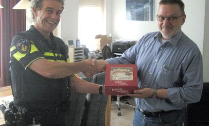 eric van Dijk overhandigt de "Bedankttaart"voor de heer en mevrouw Cools 